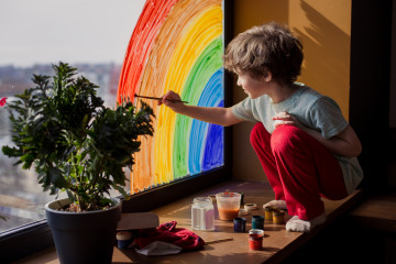 Kind malt auf Fenster